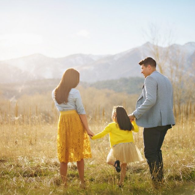 family holding hands walking away into a golden field - boulder family photographer