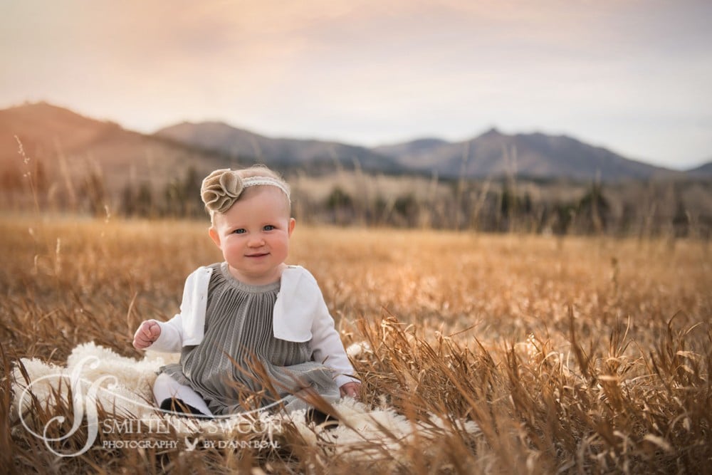 six month baby girl sitting up in a field at sunset with mountain views {boulder baby photographer}