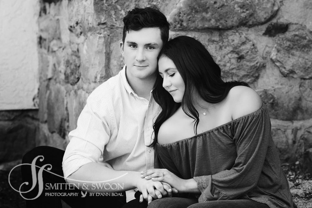 stunning couple holding each other in front of stone wall
