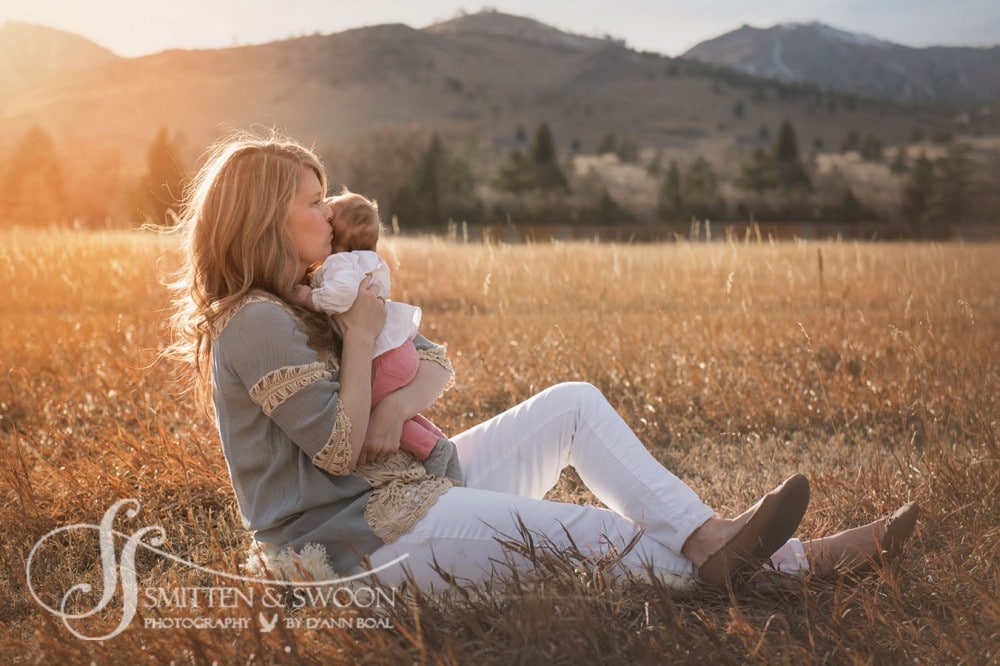 mom holding her baby sitting in a golden field {boulder baby photographer}