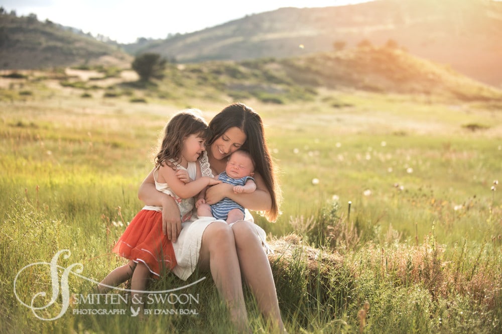 mom holding her newborn boy and toddler girl in field hugging {boulder family photographer}
