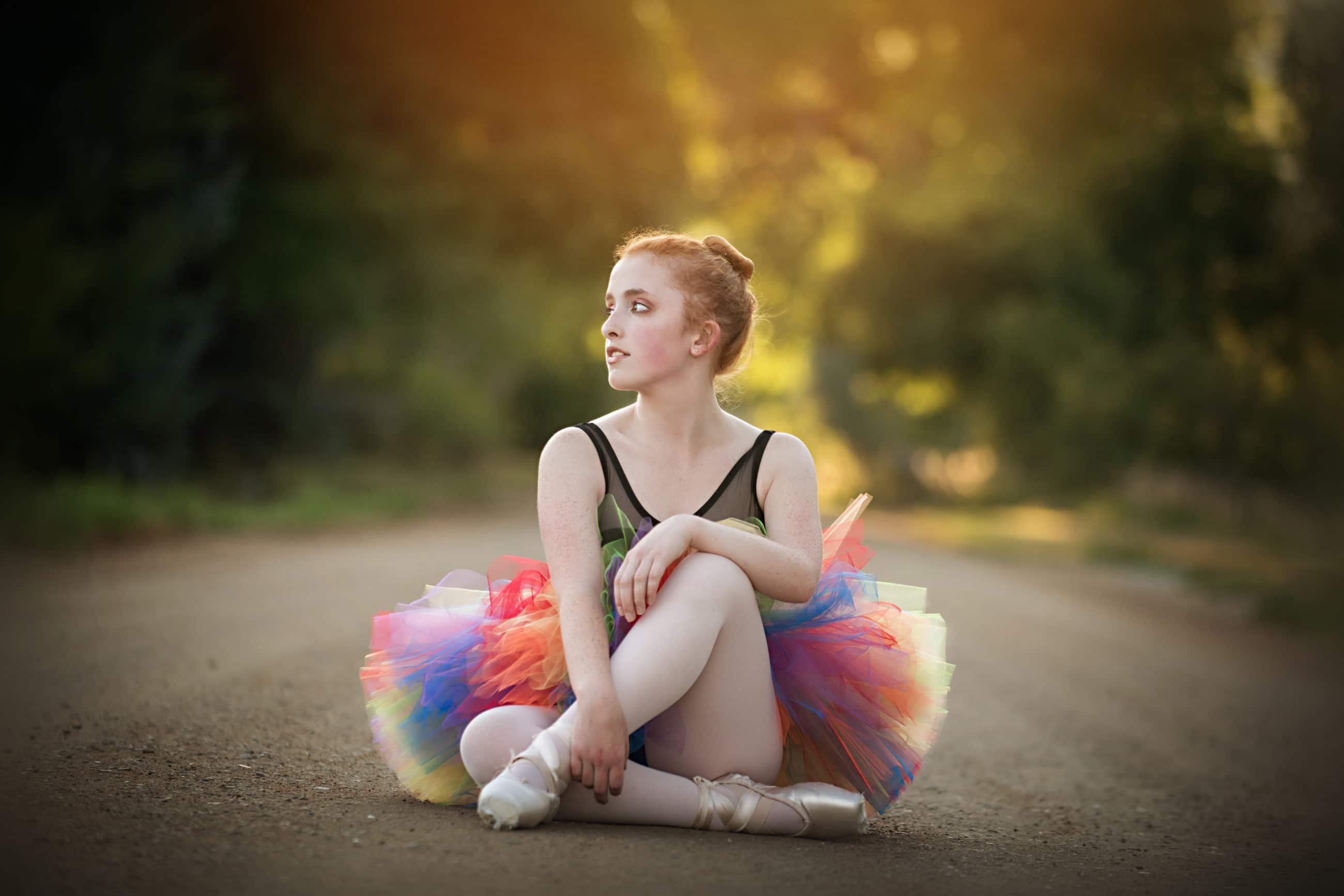 ballerina sitting on dirt road with pointe shoes and tutu - boulder senior photographer