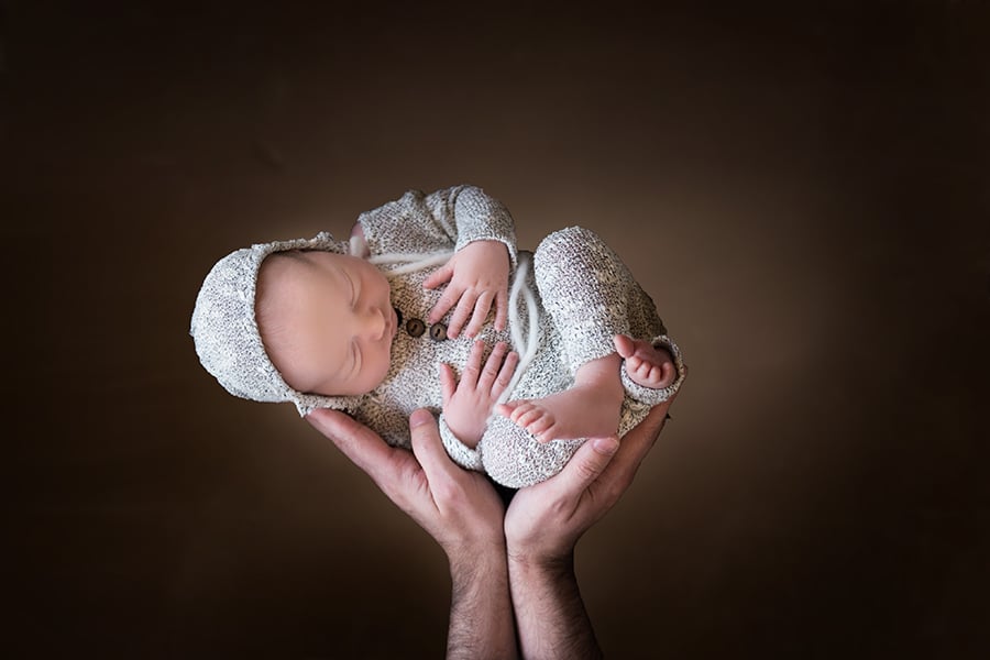 newborn baby up in the air in dad's hands - newborn photographer boulder
