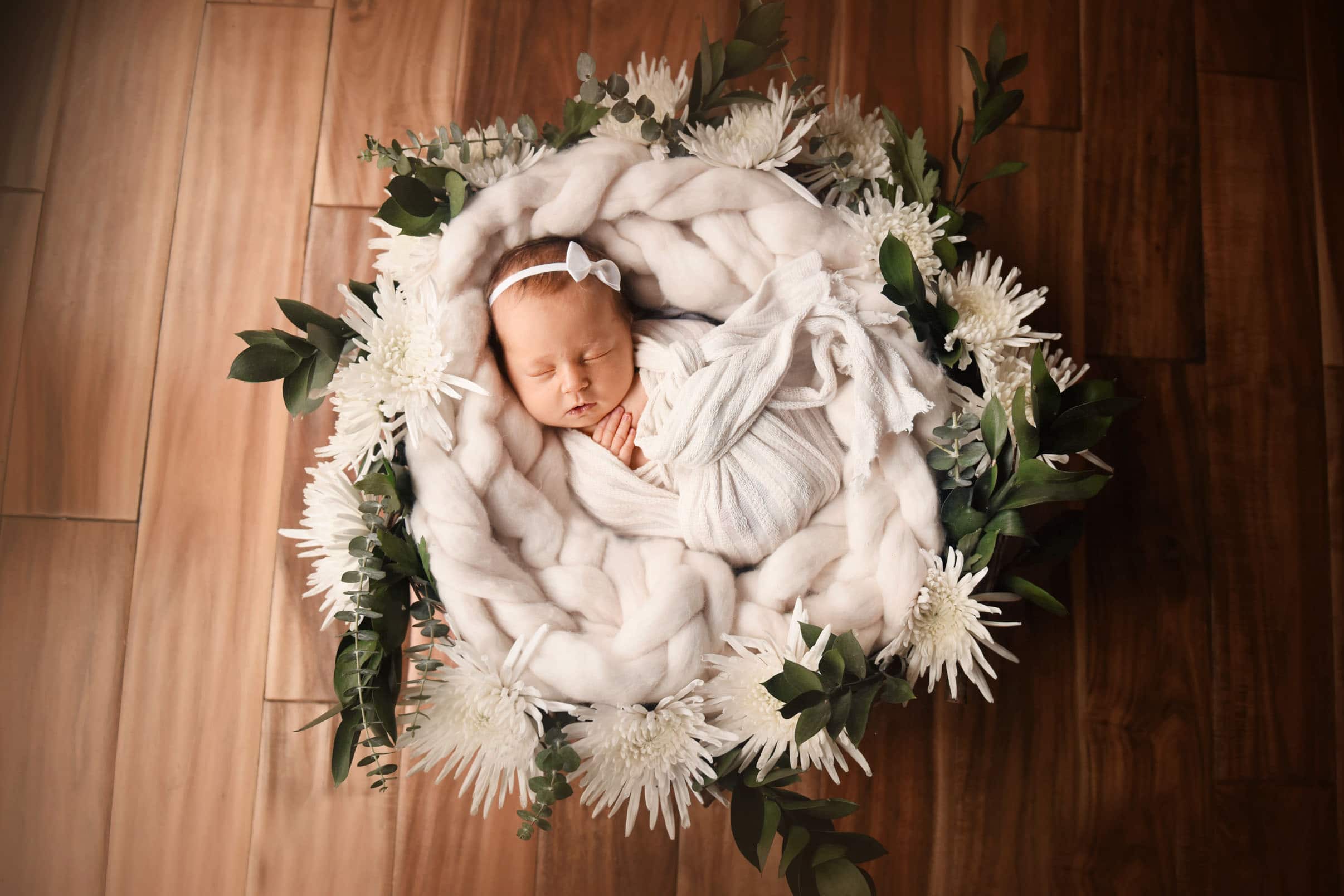 newborn baby girl posed with white flowers - boulder photographer