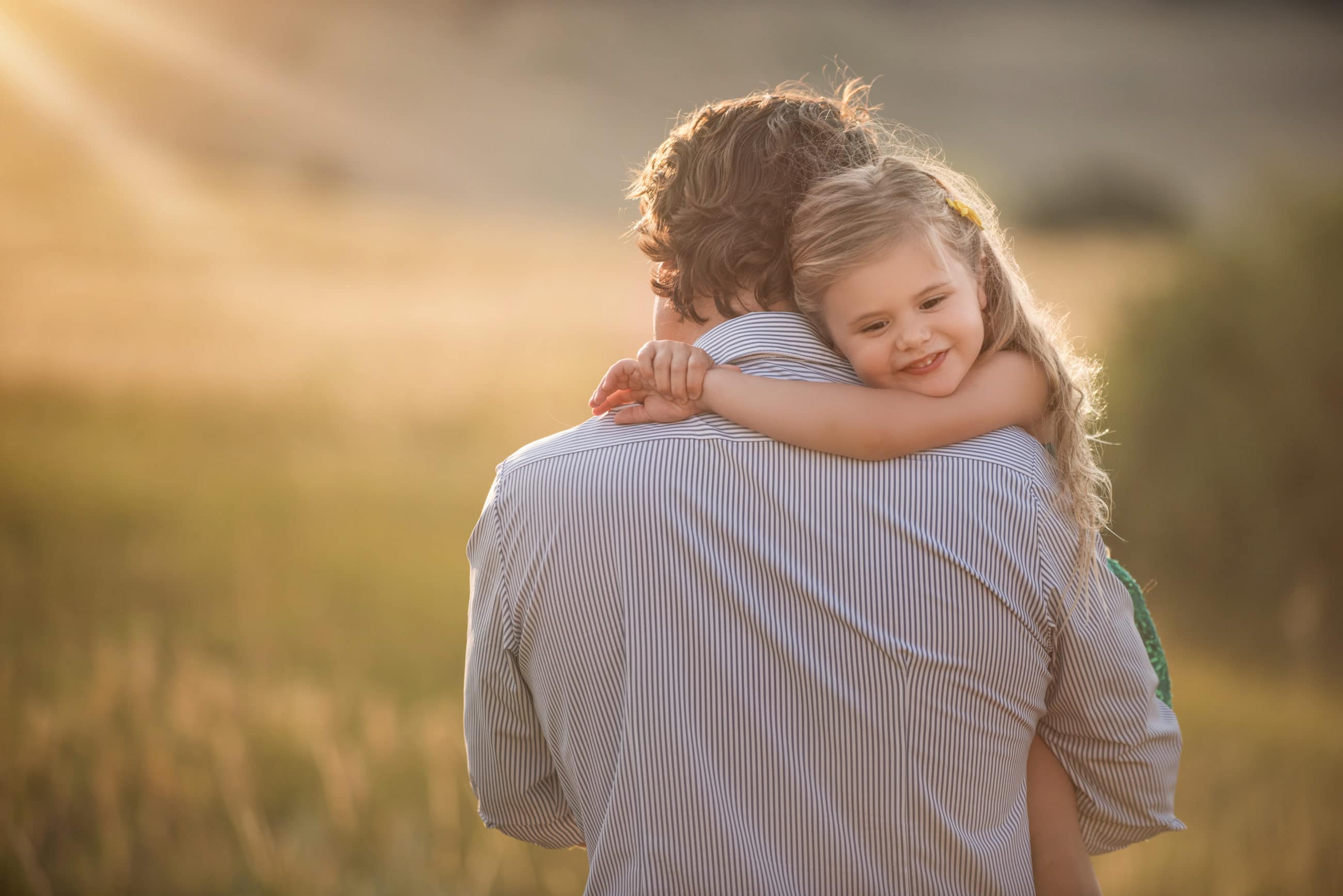 dad holding daughter who is smiling - boulder family photographer