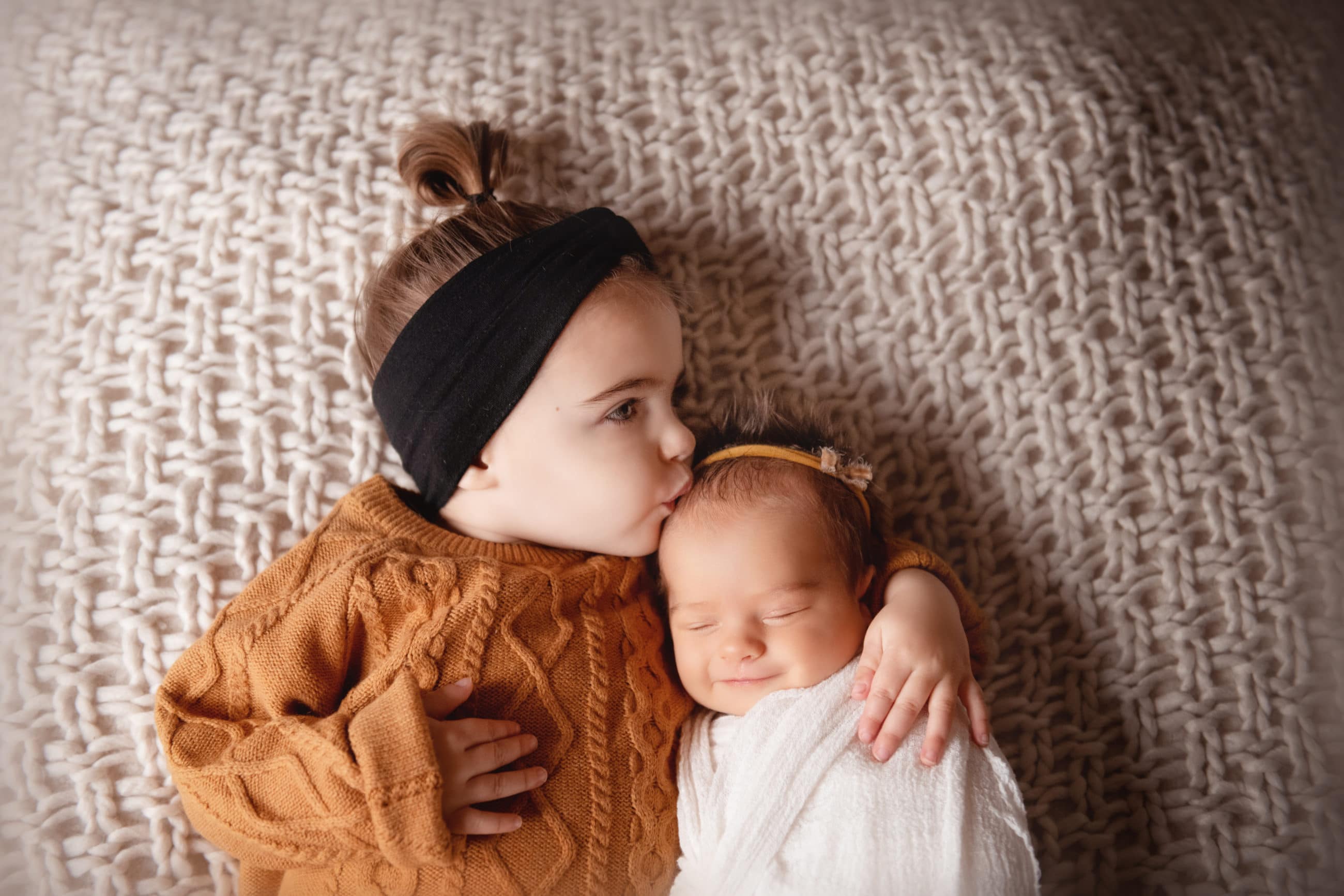 little girl kissing newborn baby sister - boulder newborn baby photographer