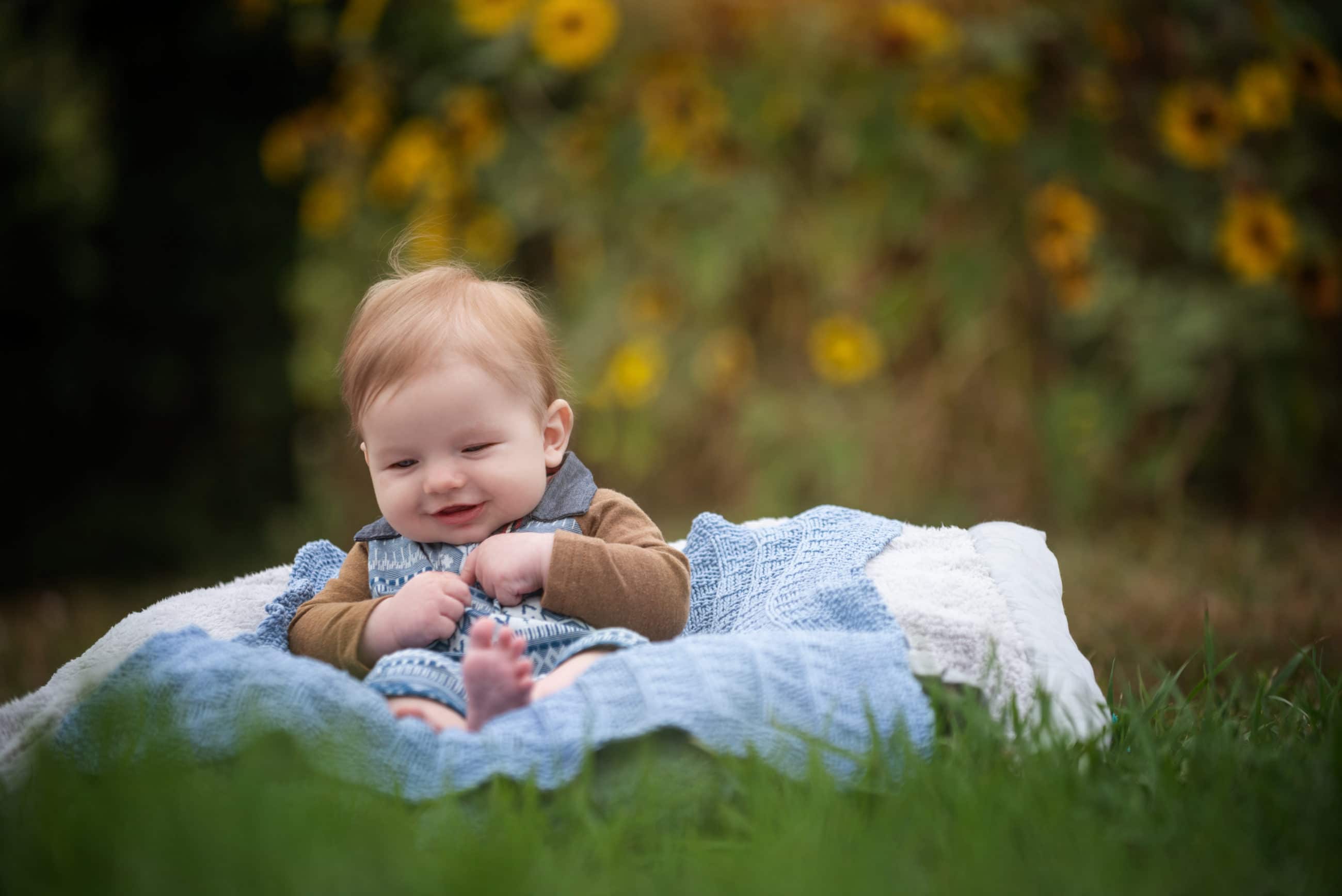 three month old baby boy outside with sunflowers - boulder photographer