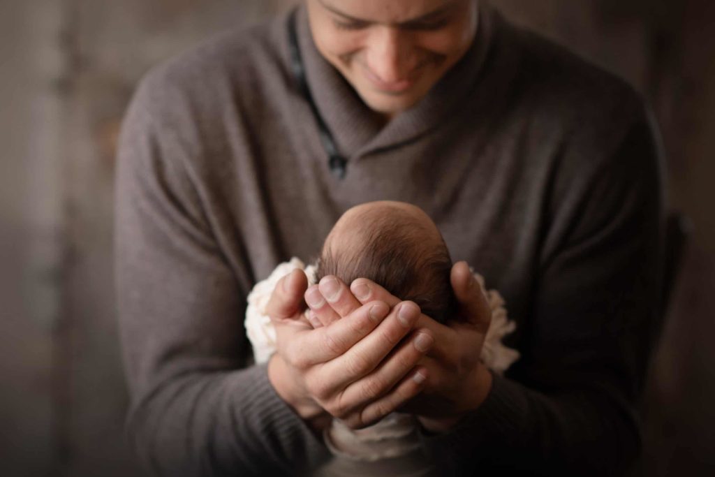 dad wearing sweater holding newborn baby Boulder photographer newborn