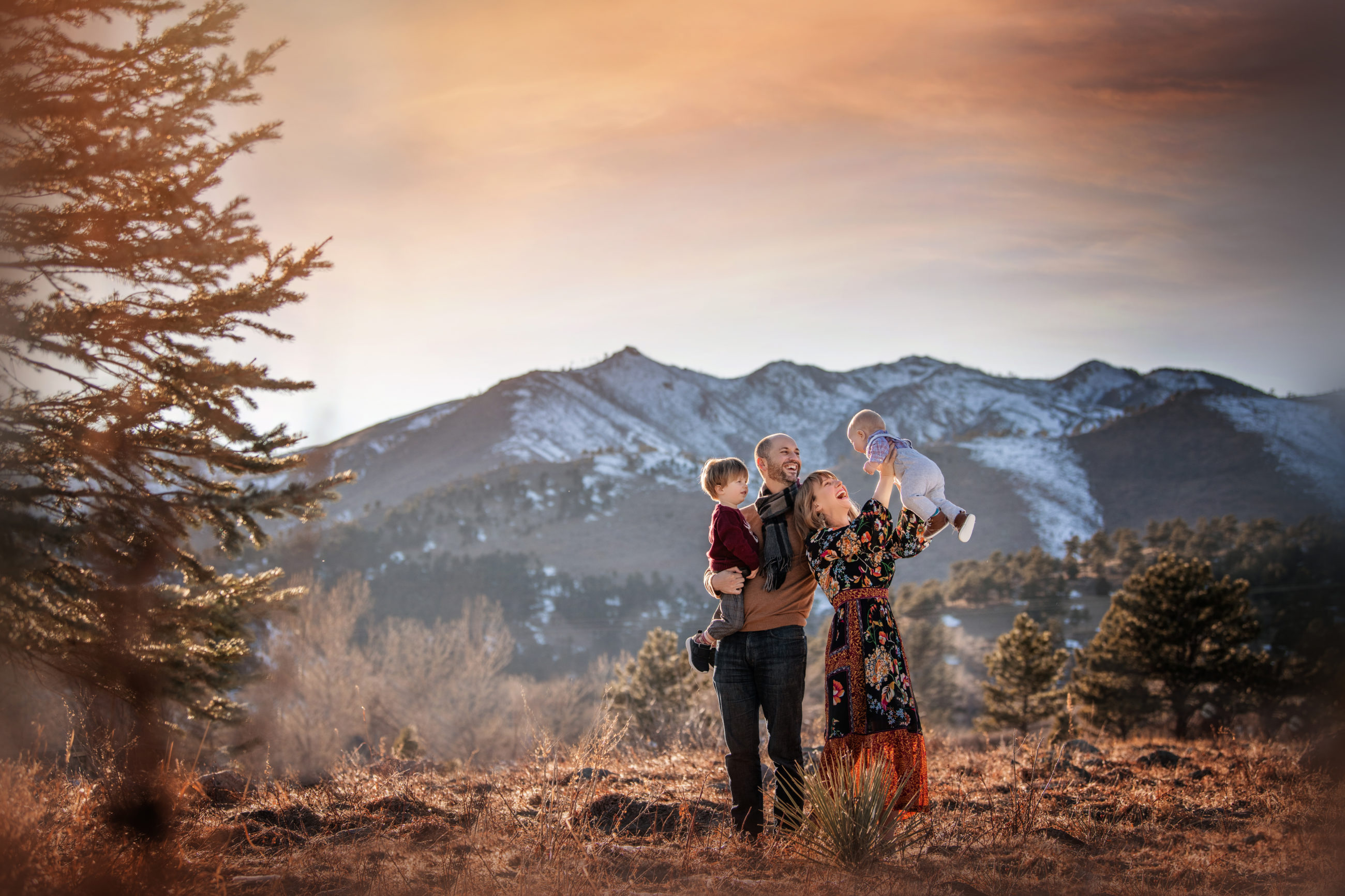 love and light - boulder photographer - family of four mom holding baby up to sky