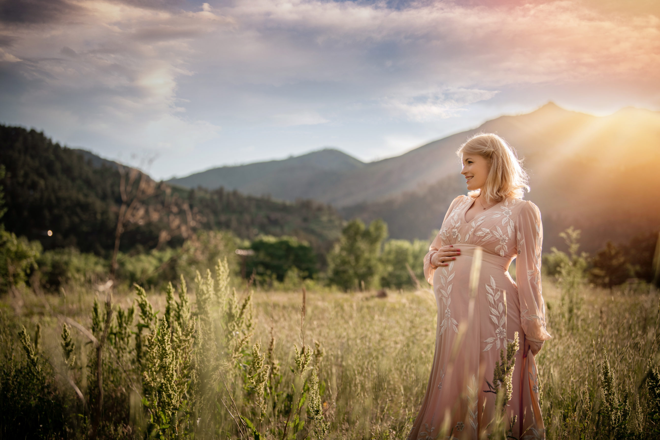 maternity photo pregnant woman in pink dress in field at sunset Boulder Photographer | Newborn & Maternity Session