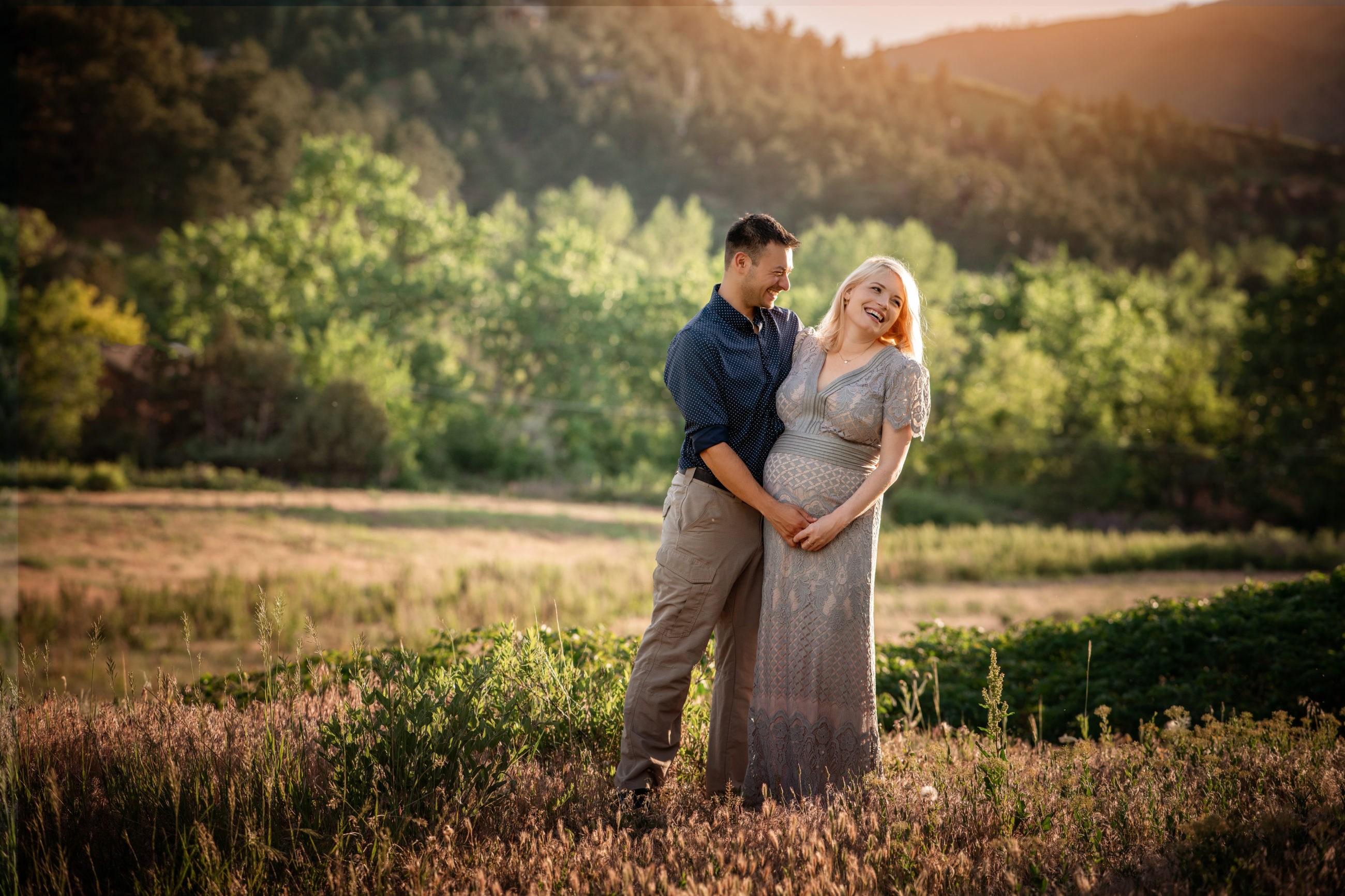 Boulder Photographer | Newborn & Maternity Session - happy couple laughing in beautiful field at sunset maternity