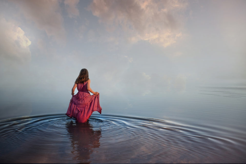 girl in pink dress walking into beautiful water that meets the sky - boulder photographer